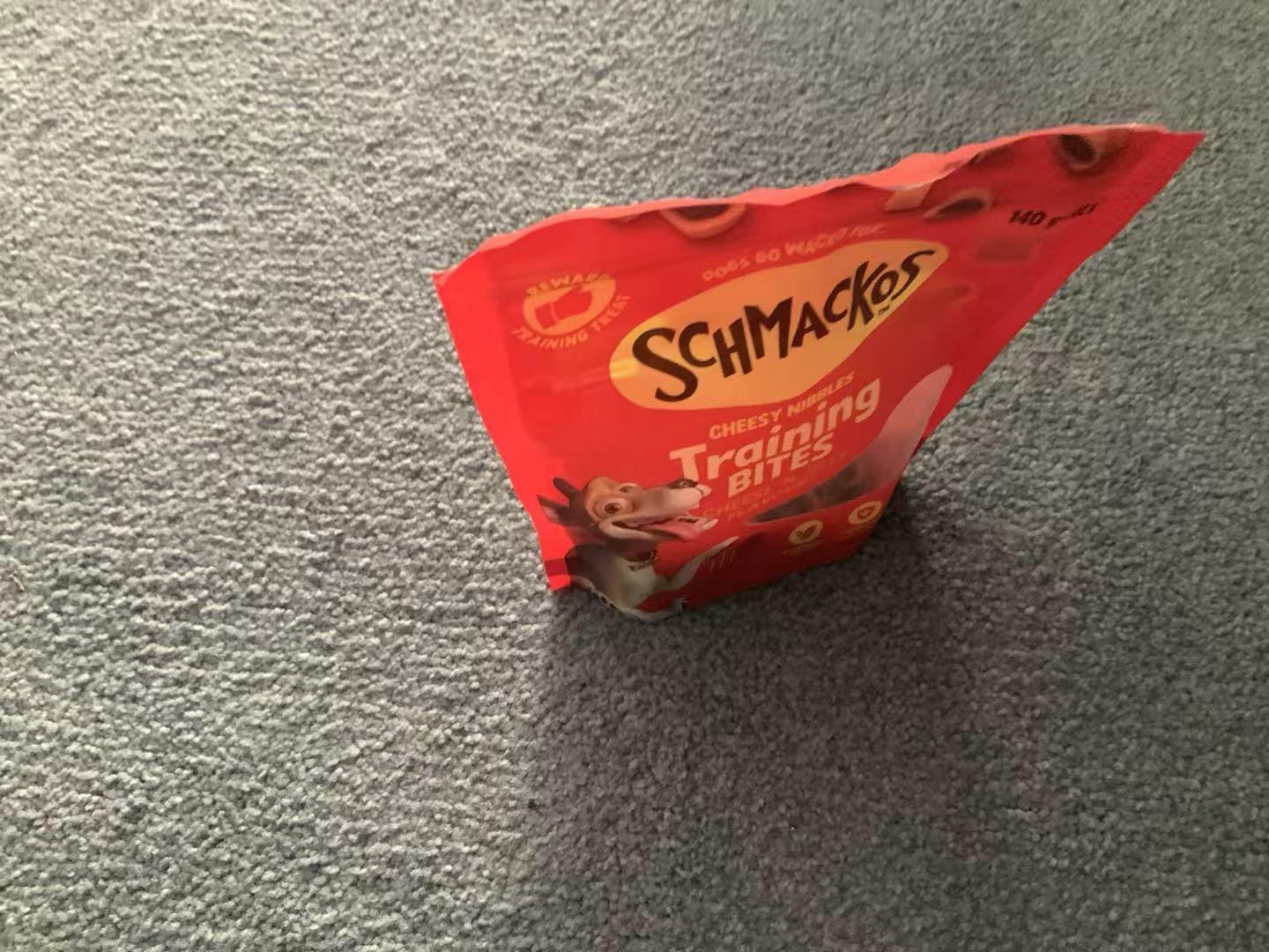 A red bag of Schmackos Cheesy Nibbles dog treats